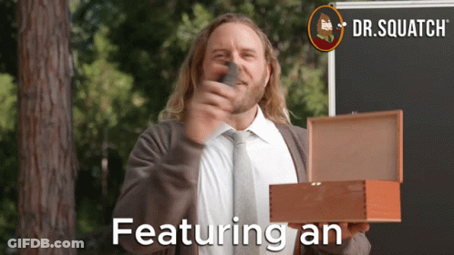 A Man In A Suit And Tie Is Holding A Box That Says Featuring An On It GIF