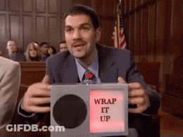 A Man In A Suit And Tie Is Holding A Box That Says " Wrap It Up " GIF