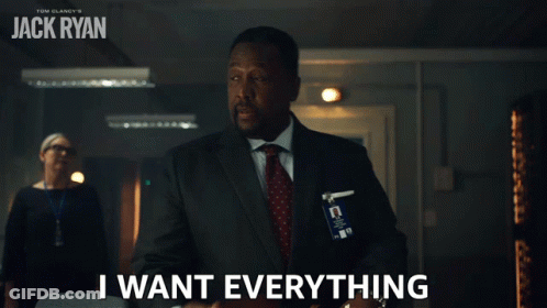 A Man In A Suit And Tie Is Holding A Briefcase And Says " I Want Everything " GIF