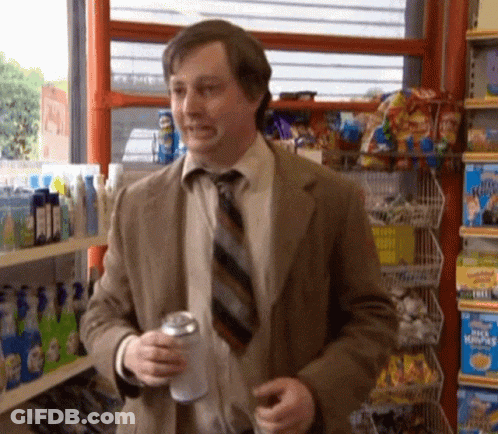 A Man In A Suit And Tie Is Holding A Can Of Soda GIF