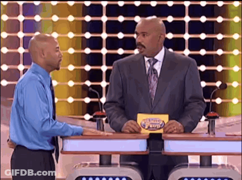 A Man In A Suit And Tie Is Holding A Card That Says ' The Price Is Right ' On It GIF