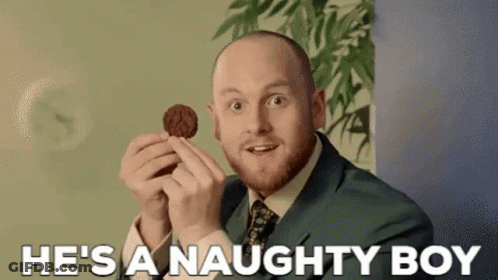 Man In Suit Holding Cookie Says Naughty Boy GIF