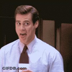 A Man In A Suit And Tie Is Holding A Cup And Making A Funny Face GIF