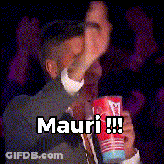 A Man In A Suit And Tie Is Holding A Cup That Says Mauri !!! GIF