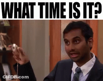 A Man In A Suit And Tie Is Holding A Donut And Asking What Time Is It . GIF