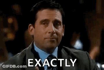A Man In A Suit And Tie Is Holding A Drink And Making A Funny Face . GIF