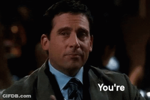A Man In A Suit And Tie Is Holding A Drink In His Hand And The Word Welcome Is Behind Him GIF