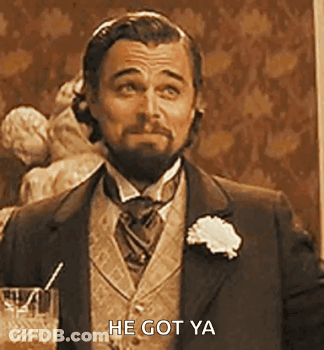 A Man In A Suit And Tie Is Holding A Glass Of Whiskey And A Straw . GIF
