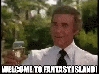 A Man In A Suit And Tie Is Holding A Glass Of Wine And Saying `` Welcome To Fantasy Island '' . GIF