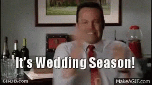A Man In A Suit And Tie Is Holding A Glass Of Wine And Says `` It 'S Wedding Season ! '' GIF