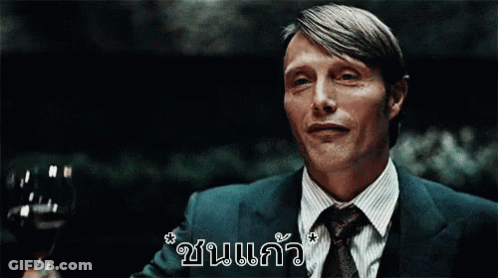 A Man In A Suit And Tie Is Holding A Glass Of Wine In His Hand GIF