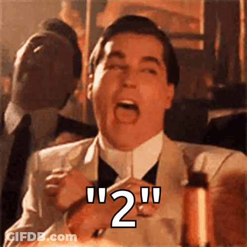 A Man In A Suit And Tie Is Holding A Glass With The Number 2 Written On It . GIF