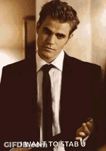 A Man In A Suit And Tie Is Holding A Gun And Saying `` I Want To Stab U '' . GIF