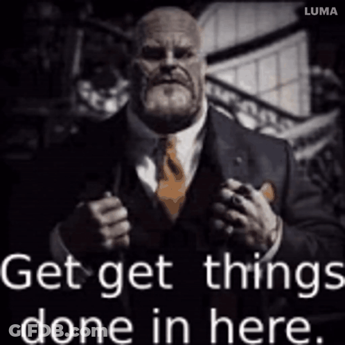 A Man In A Suit And Tie Is Holding A Gun And Says Get Things Done In Here GIF