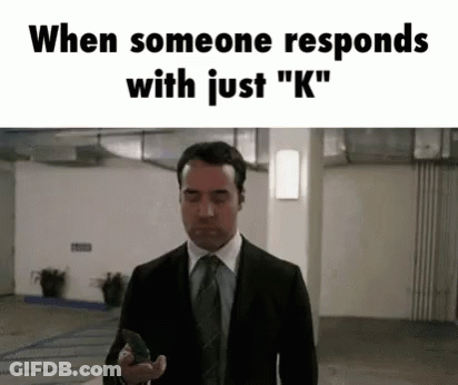 A Man In A Suit And Tie Is Holding A Gun In A Garage . GIF
