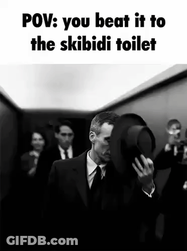 A Man In A Suit And Tie Is Holding A Hat Over His Face . GIF
