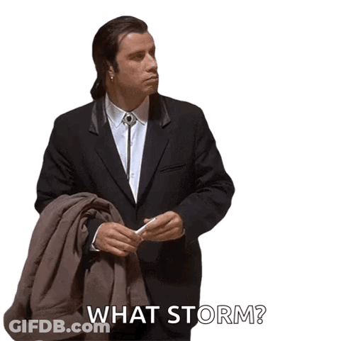 A Man In A Suit And Tie Is Holding A Jacket And Says What Storm GIF