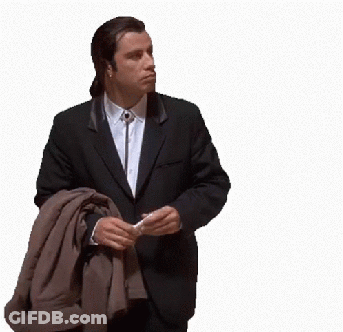 A Man In A Suit And Tie Is Holding A Jacket Over His Shoulder GIF