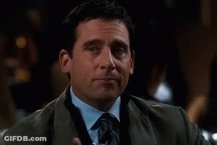 A Man In A Suit And Tie Is Holding A Martini Glass In His Hand . GIF