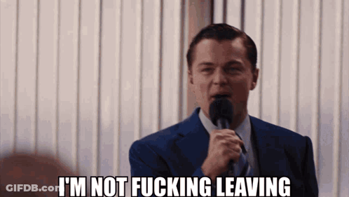 A Man In A Suit And Tie Is Holding A Microphone And Says I 'M Not Fucking Leaving GIF