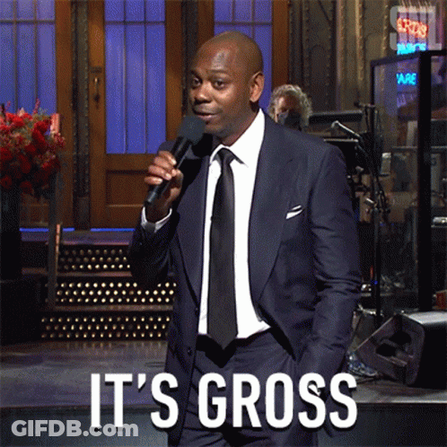 A Man In A Suit And Tie Is Holding A Microphone And Says It 'S Gross On The Bottom GIF