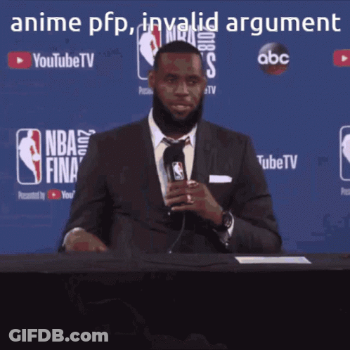 A Man In A Suit And Tie Is Holding A Microphone In Front Of A Nba Finals Sign GIF