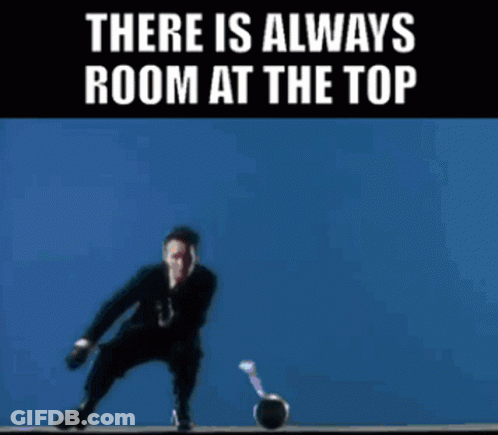 A Man In A Suit And Tie Is Holding A Microphone In Front Of A Yellow Background That Says There Is Always Room At The To GIF