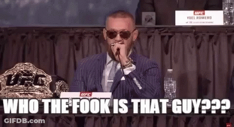 A Man In A Suit And Tie Is Holding A Microphone In His Mouth . GIF