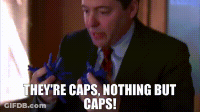 A Man In A Suit And Tie Is Holding A Pair Of Scissors And Says They 'Re Caps , Nothing But Caps GIF