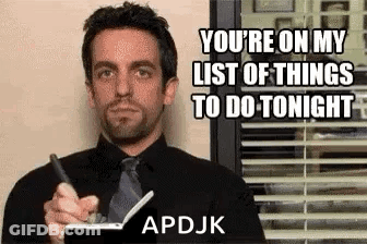 A Man In A Suit And Tie Is Holding A Pen And A Notebook . GIF