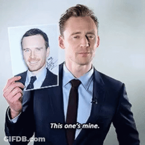 A Man In A Suit And Tie Is Holding A Picture Of Another Man And Saying This One 'S Mine . GIF