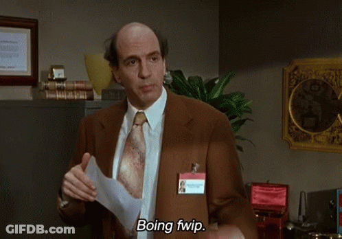 A Man In A Suit And Tie Is Holding A Piece Of Paper And Says Boing Fwip GIF