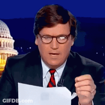 A Man In A Suit And Tie Is Holding A Piece Of Paper In Front Of The Capitol Building . GIF