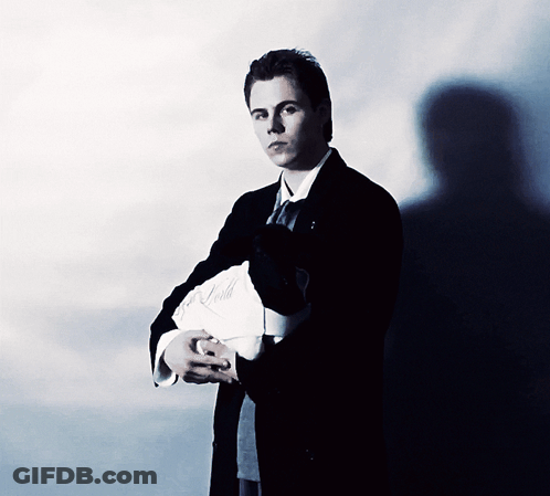 A Man In A Suit And Tie Is Holding A Piece Of Paper That Says ' A. Smith ' On It GIF