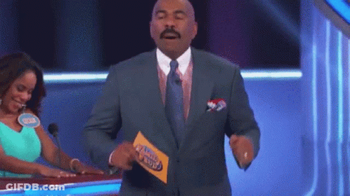 A Man In A Suit And Tie Is Holding A Piece Of Paper That Says Family Feud .. GIF