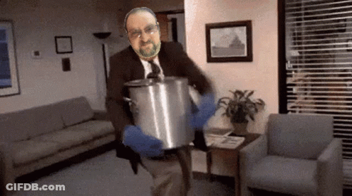 A Man In A Suit And Tie Is Holding A Pot GIF