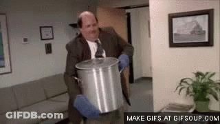 A Man In A Suit And Tie Is Holding A Pot In His Hands . GIF