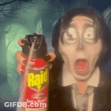 A Man In A Suit And Tie Is Holding A Raid Ant Spray . GIF