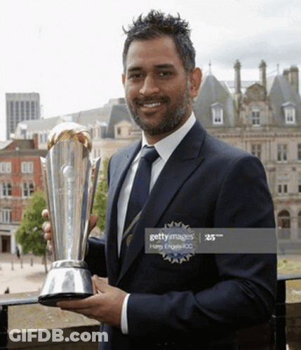 A Man In A Suit And Tie Is Holding A Trophy GIF