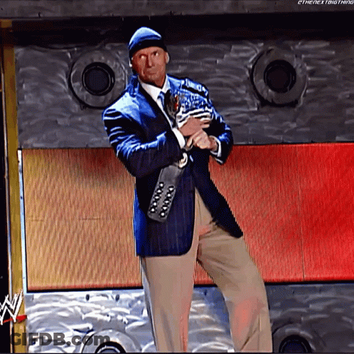 A Man In A Suit And Tie Is Holding A Trophy In Front Of A Wall That Says Ethenextbigthing GIF