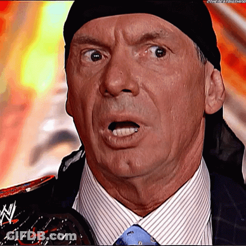A Man In A Suit And Tie Is Holding A Wrestling Trophy And Making A Surprised Face . GIF