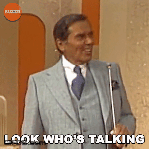A Man In A Suit And Tie Is Holding An Umbrella And Says " Look Who 'S Talking " GIF