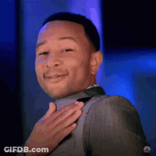 A Man In A Suit And Tie Is Holding His Hand To His Chest . GIF