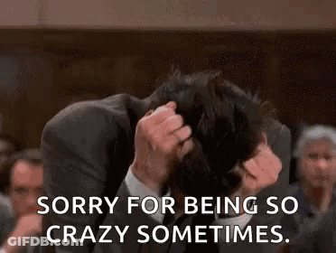 A Man In A Suit And Tie Is Holding His Head In His Hands And Says `` Sorry For Being So Crazy Sometimes . '' GIF