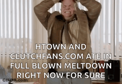 A Man In A Suit And Tie Is Holding His Head In His Hands While Standing In Front Of A Window . GIF