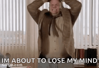 A Man In A Suit And Tie Is Holding His Head While Screaming . GIF