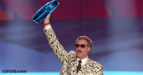 A Man In A Suit And Tie Is Holding Up A Blue Bottle That Says ' Jbl ' On It GIF