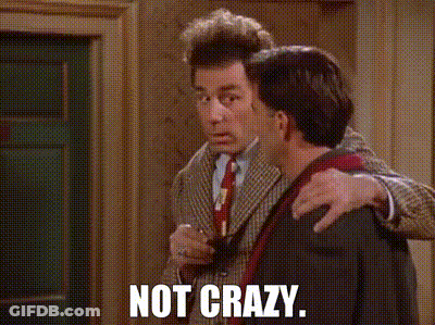 A Man In A Suit And Tie Is Hugging Another Man With The Words Not Crazy Written On The Screen . GIF