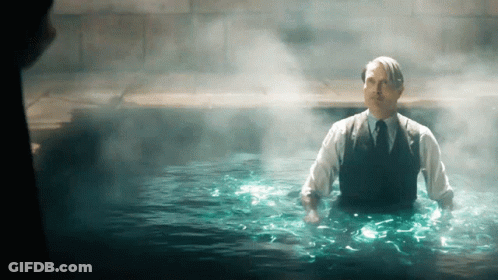 A Man In A Suit And Tie Is In A Pool Of Water GIF