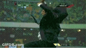 A Man In A Suit And Tie Is Jumping In The Air During A Soccer Match GIF